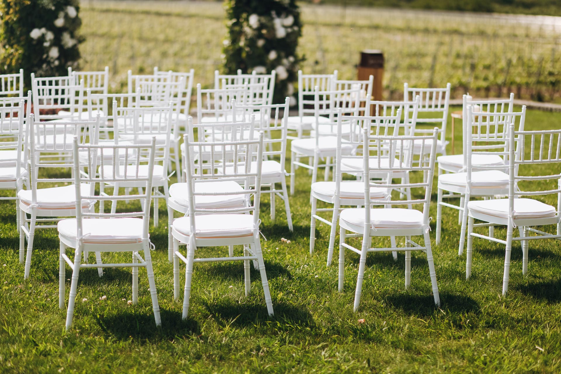 sillas-blancas-hierba-frente-ceremonia-de-boda-arco